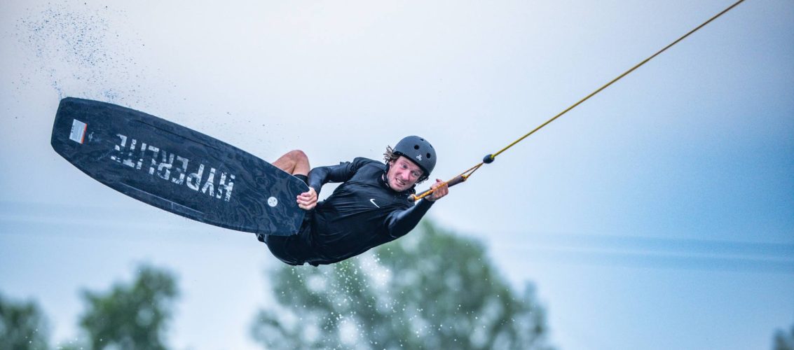 Rider executando manobra de wakeboard no cable park